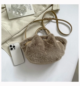 Flat lay of brown plush crossbody bag with leather strap and urban lifestyle props
