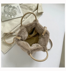 Detail view of khaki faux fur bag interior showing plush texture and metal hardware