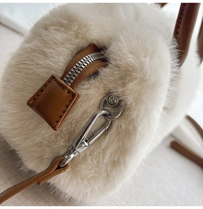 Dettaglio della morbida pelliccia sintetica bianca con pelle marrone e metallo argento