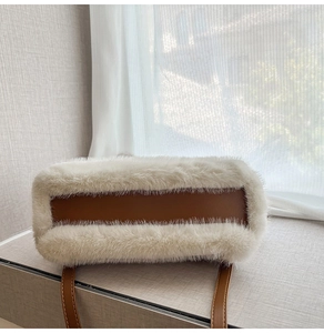 Dettaglio borsa in peluche bianca con base in pelle marrone e tracolla rifinita