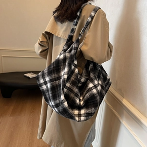 Grand sac cabas à carreaux noir et blanc avec bandoulière réglable porté par un mannequin