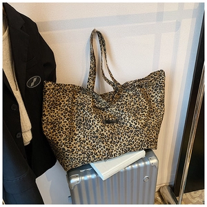 Detailed view of leopard print tote bag placed on a silver suitcase for stylish travel