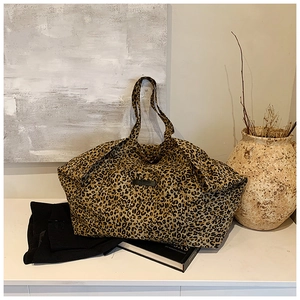 Detail of large leopard print canvas tote bag in a minimalist home interior setting