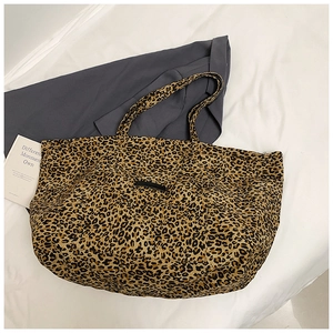 Detail of leopard print tote bag with black patch on textured fabric canvas