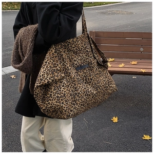 Detailed side view of leopard print tote bag featuring black My Sunday leather brand label