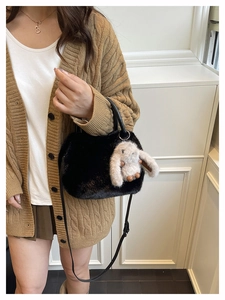 Detail of black faux fur handbag with cute rabbit plush charm and adjustable strap