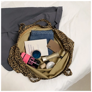 Top-down view of spacious leopard print tote bag showing daily essentials inside