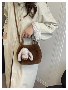 Brown plush handbag with cute white rabbit charm worn with a beige autumn trench coat