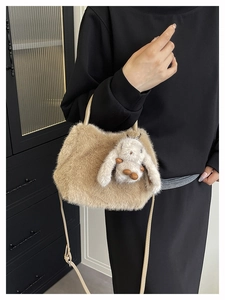 Close-up of khaki plush crossbody bag with a cute rabbit charm and shoulder strap
