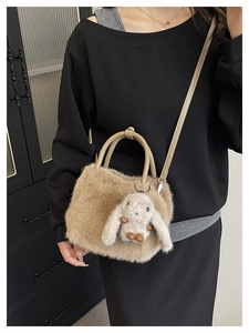 Detail of light brown faux fur handbag featuring a cute white bunny plush pendant