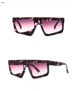 Detail view of oversized geometric sunglasses with purple marble frame and pink gradient lenses