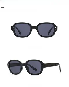 Close-up of black retro square sunglasses with silver stud accents and dark grey lenses