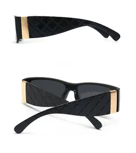 Detail view of square black sunglasses featuring quilted temples and gold metal accents