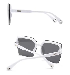 Detail view of white acetate frame sunglasses featuring gold temple metal accents
