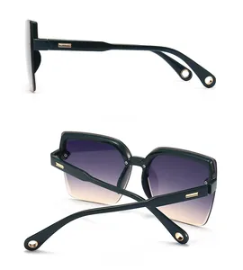Detail view of square cat eye sunglasses with side gold accents and gradient lenses