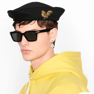 Détail de lunettes de soleil papillon noires tendance avec broderie dorée sur un béret