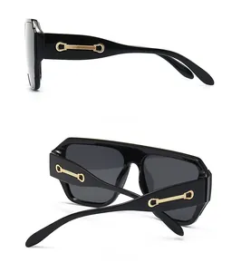 Vue détaillée des lunettes de soleil vintage noires avec charnière dorée et cadre poli