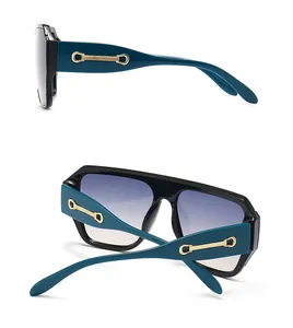 Détail de lunettes de soleil avec branches bleues, chaîne dorée et verres dégradés