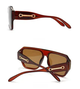 Détails des lunettes de soleil en écaille avec décorations métalliques dorées
