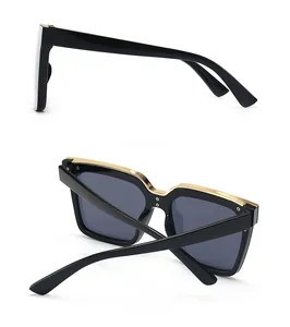 Side and back view of oversized black square cat eye sunglasses with gold metal trim