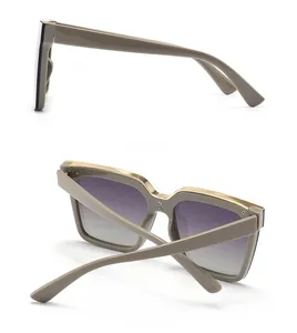 Detail view of cat eye sunglasses with purple gradient lenses and gold metal trim