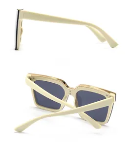 Detail view showing the side and back of cream white cat-eye sunglasses with gold metal trim