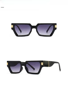 Macro detail of black square sunglasses with gold metal hinges and crocodile texture arms