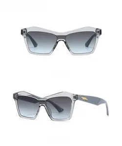 Front and side view of cat-eye sunglasses with grey blue gradient lenses and gold trim