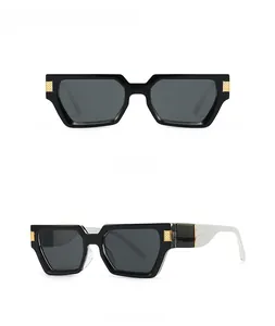 Detail of square oversized sunglasses with gold woven hinge and white crocodile pattern arm