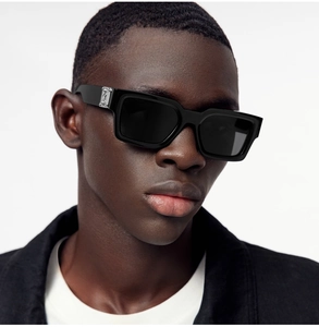 Gros plan sur des lunettes de soleil carrées noires avec détails argentés en relief