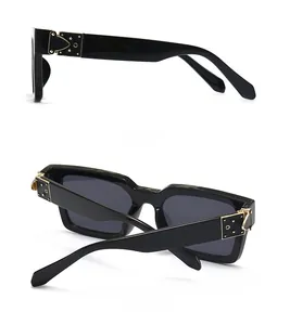 Vue détaillée de côté et de dos de lunettes de soleil carrées noires avec rivets dorés