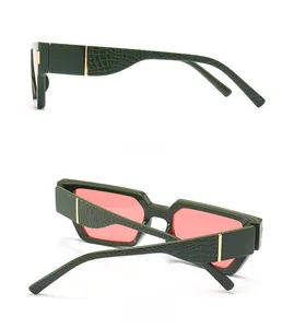 Detail view of square green sunglasses with crocodile texture and gold metal accents