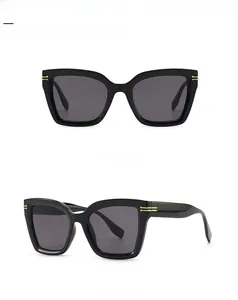 Detailansicht der schwarzen ovalen Sonnenbrille mit Goldakzenten und grauen Gläsern