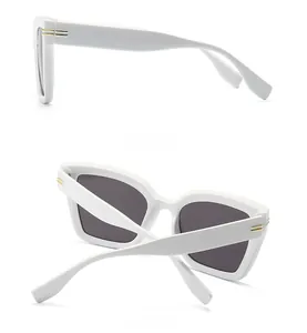 Detailansicht der ovalen weißen Sonnenbrille mit goldenen Akzenten von der Seite
