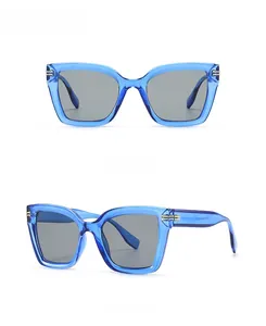 Detail der blauen ovalen Sonnenbrille mit grauen Gläsern und goldenen Metallakzenten