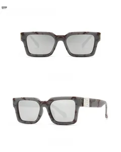 Détail de lunettes carrées effet marbre avec verres gris mercure et accents métalliques