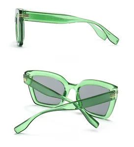 Detailansicht der ovalen Sonnenbrille mit grünen Jelly-Rahmen und Schottenmuster-Bügeln