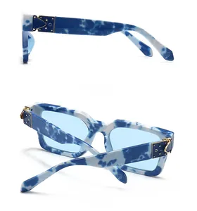 Détail de la monture effet marbre bleu et charnière en métal doré des lunettes de soleil