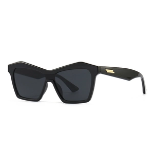 Modern cat-eye sunglasses in black acetate with elegant gold metal temple details
