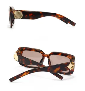 Detail view of tortoiseshell sunglasses with brown lenses and golden metal temple accents