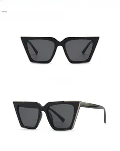 Front and side view of trendy black cat eye sunglasses with gold metal trim and grey lenses