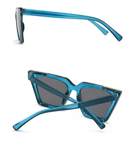 Detail view of transparent blue cat-eye sunglasses with metal bar and grey lenses