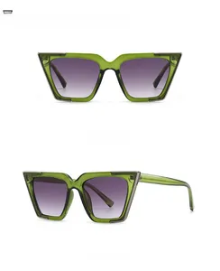Detail view of cat-eye sunglasses with green frames and purple gradient lenses