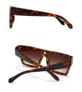 Detail of tortoise shell sunglasses with gold metal bar and brown gradient lenses