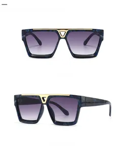 Flat top sunglasses with blue tortoiseshell frame and V-shaped gold metal bridge detail