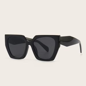 Lunettes de soleil oversize polygonales noires avec verres gris foncé en vue de studio 45°