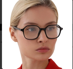 Detail of black hexagonal eyeglass frames with silver metallic hinge branding on a model