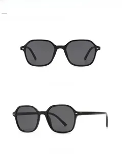Detail of retro hexagonal sunglasses with black frames and metal rivet accents