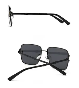 Vue détaillée des lunettes de soleil carrées rétro avec montures noires et charnières