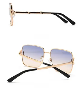 Détails de lunettes de soleil carrées avec monture dorée et verres dégradés violets